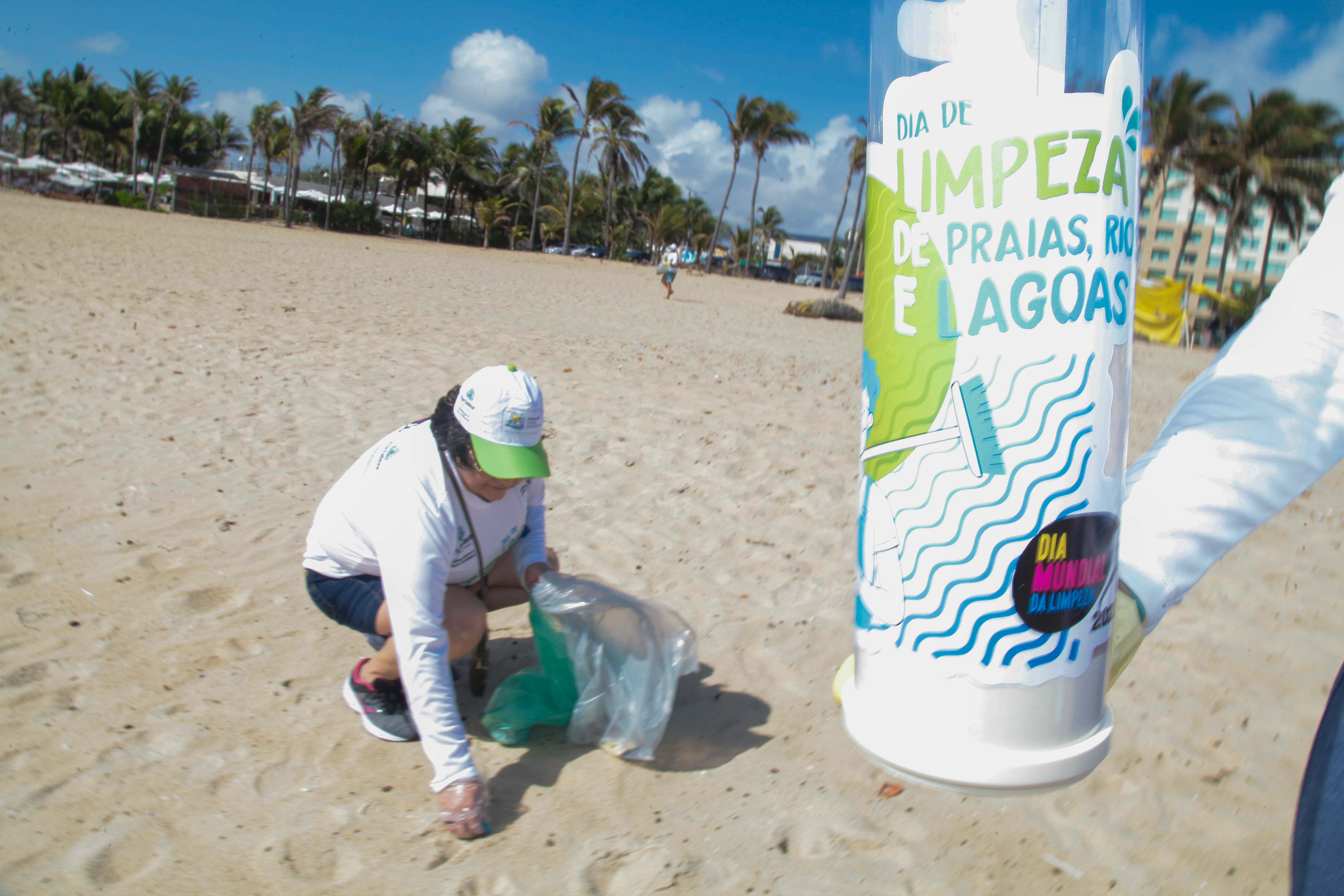 pessoas recolhendo lixo na praia